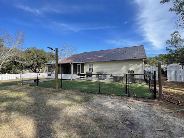 rear view of house with a yard and a sunroom