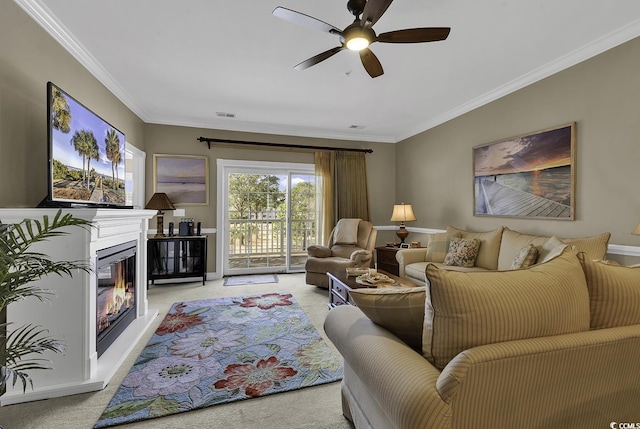 carpeted living room featuring ornamental molding and ceiling fan