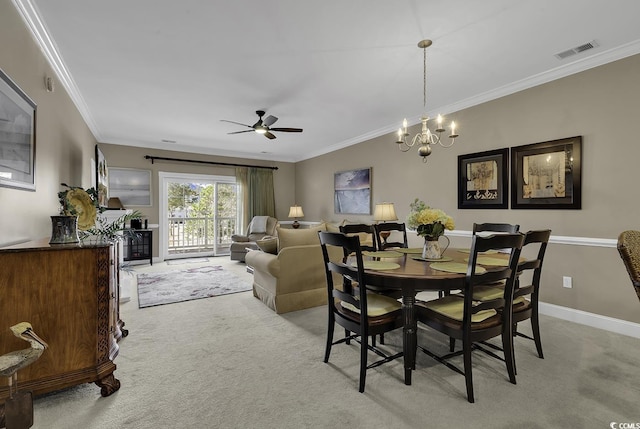 dining space with ornamental molding, ceiling fan with notable chandelier, and light carpet