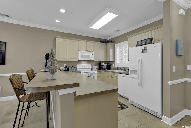 kitchen with a breakfast bar, sink, kitchen peninsula, white appliances, and cream cabinets