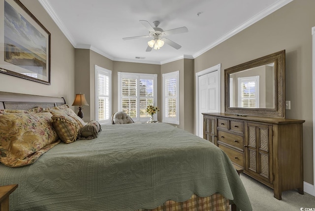 carpeted bedroom featuring ornamental molding, a closet, and ceiling fan