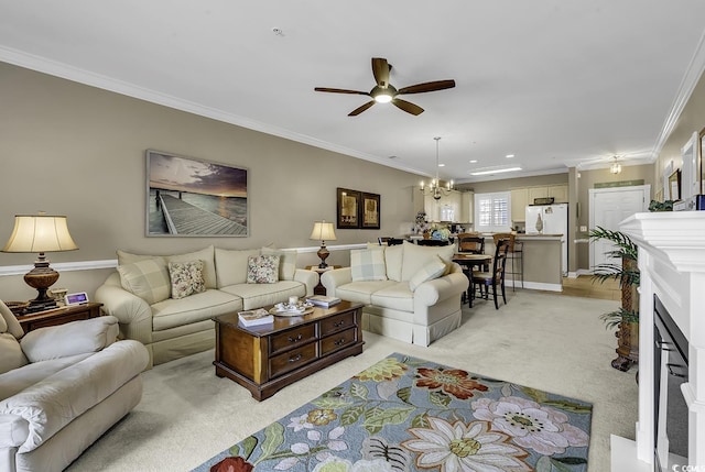 carpeted living room featuring ornamental molding and ceiling fan with notable chandelier