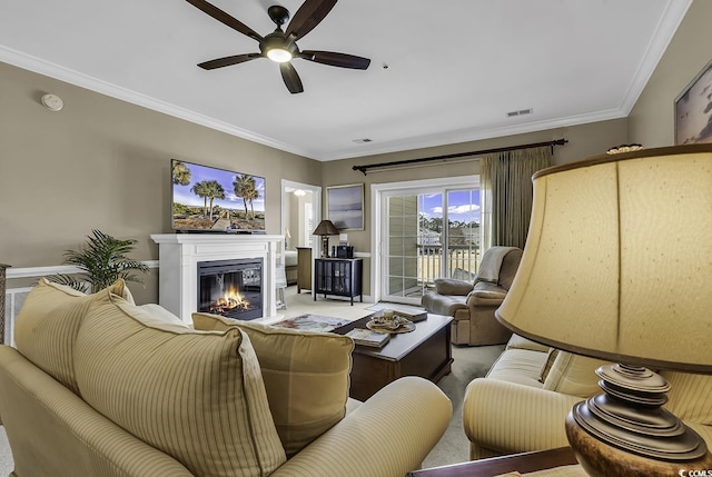 living room featuring ornamental molding, ceiling fan, and carpet flooring