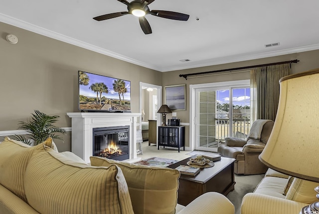 carpeted living room featuring ornamental molding and ceiling fan