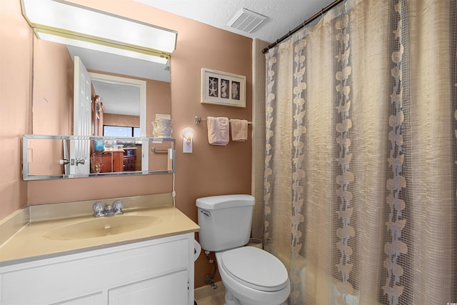 bathroom with vanity, a textured ceiling, and toilet