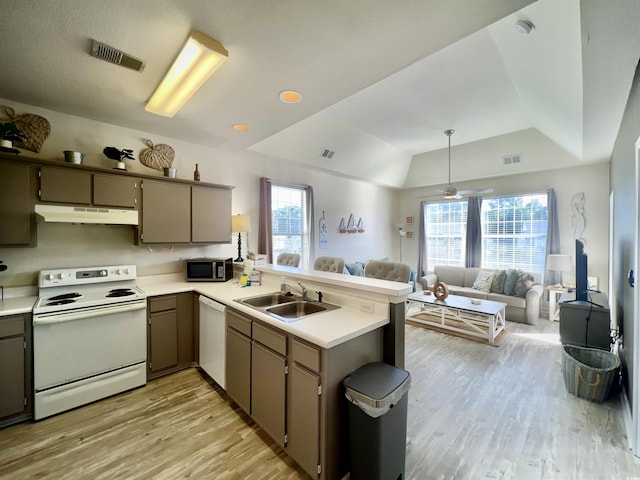 kitchen featuring white appliances, kitchen peninsula, sink, and light wood-type flooring