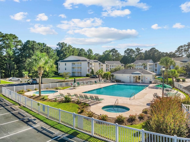 view of swimming pool featuring a hot tub and a patio area