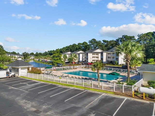 view of swimming pool featuring a water view and a patio area