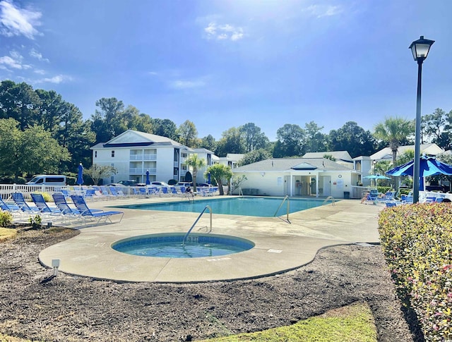 view of swimming pool featuring a community hot tub and a patio