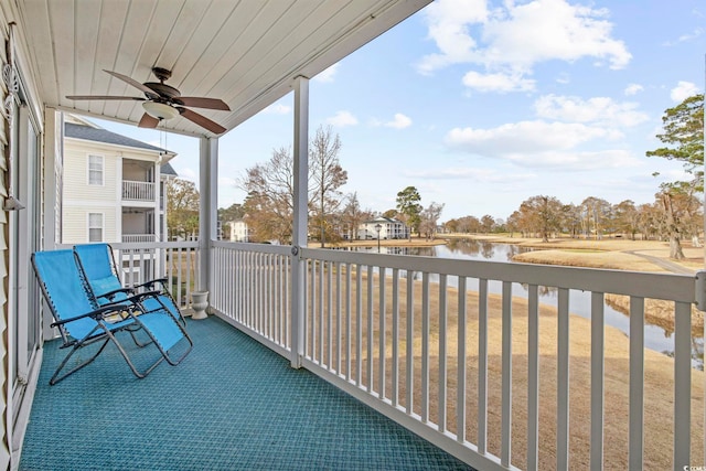 balcony with ceiling fan and a water view