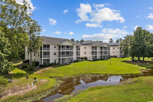 view of property's community with a lawn and a water view