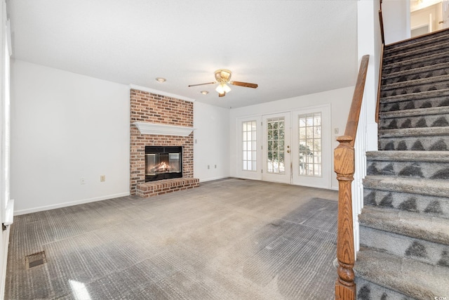 unfurnished living room with a fireplace, ceiling fan, and carpet