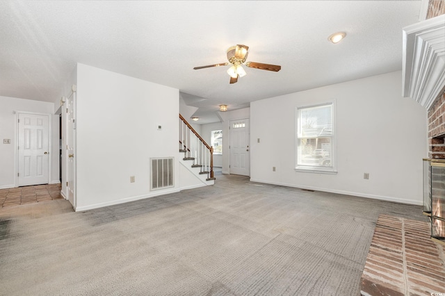 unfurnished living room with ceiling fan, light colored carpet, and a textured ceiling