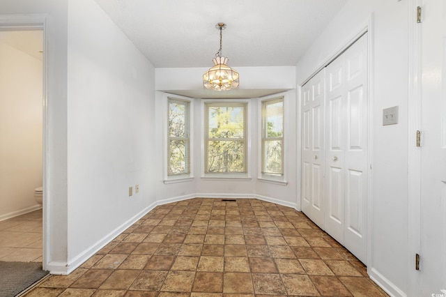 unfurnished dining area featuring an inviting chandelier