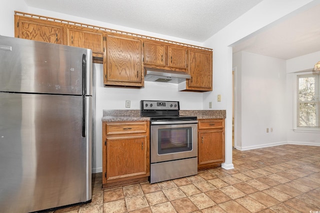 kitchen with stainless steel appliances, ventilation hood, and a textured ceiling