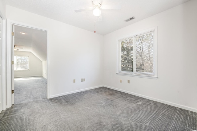 carpeted spare room featuring ceiling fan, lofted ceiling, and a textured ceiling