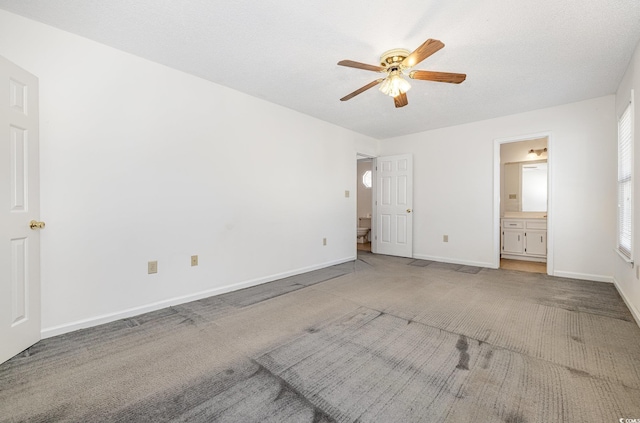 unfurnished bedroom featuring ensuite bathroom, carpet floors, ceiling fan, and a textured ceiling