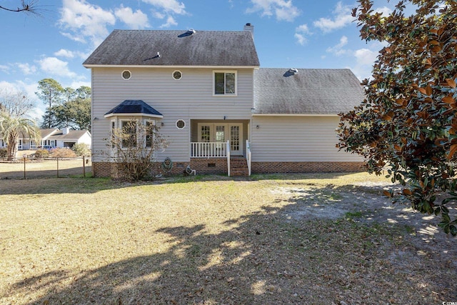 back of house featuring french doors and a lawn