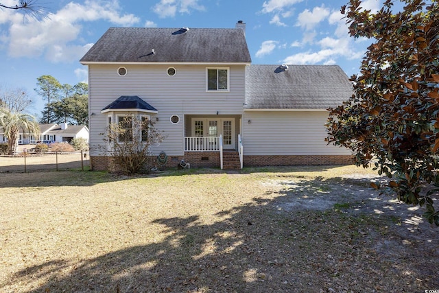 rear view of house with french doors and a yard