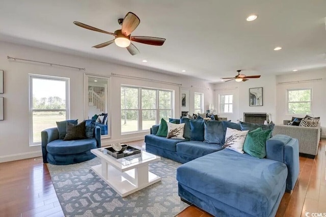 living area with a fireplace, hardwood / wood-style flooring, and recessed lighting