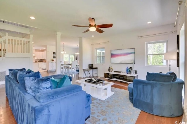 living room featuring ceiling fan with notable chandelier, recessed lighting, visible vents, and wood finished floors