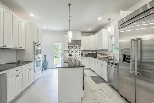 kitchen featuring under cabinet range hood, stainless steel appliances, a sink, marble finish floor, and a center island