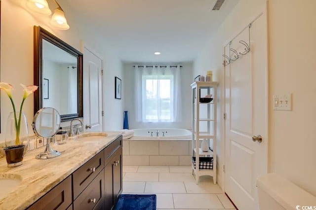 bathroom with a sink, visible vents, a bath, tile patterned floors, and double vanity