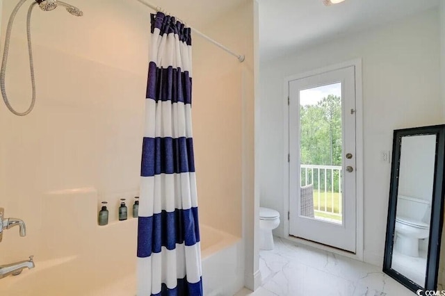 bathroom featuring toilet, marble finish floor, and shower / tub combo with curtain