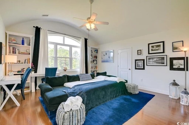 bedroom with visible vents, baseboards, ceiling fan, wood finished floors, and vaulted ceiling