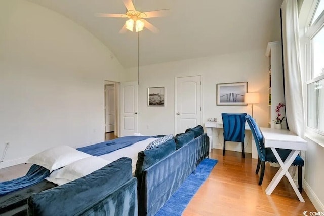 bedroom featuring lofted ceiling, ceiling fan, light wood-style flooring, and baseboards