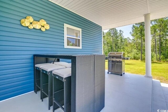 washroom featuring stacked washer and dryer, wood finished floors, and laundry area