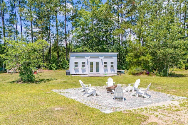 back of house with a fire pit, an outdoor structure, and a yard