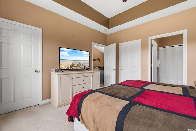 bedroom with light carpet and ensuite bath