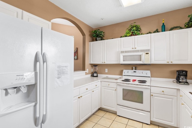 kitchen featuring light tile patterned floors, white appliances, a textured ceiling, and white cabinets