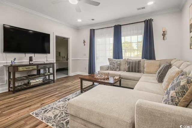 living room featuring wood-type flooring, ornamental molding, and ceiling fan