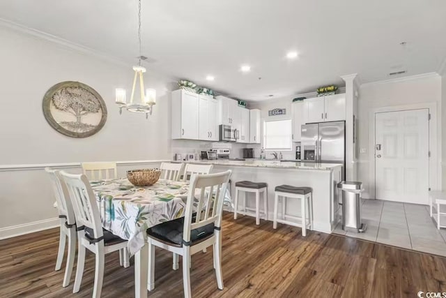 dining room featuring ornamental molding, a chandelier, and dark hardwood / wood-style flooring