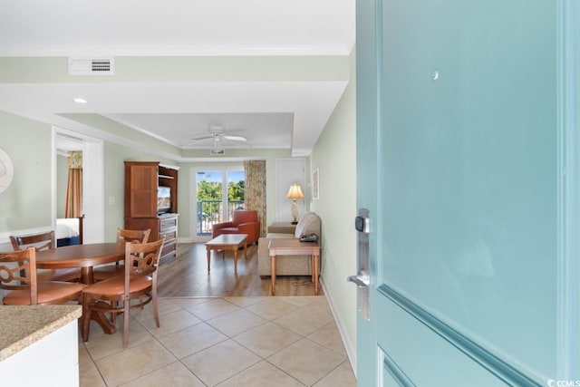 tiled dining space featuring ornamental molding and ceiling fan