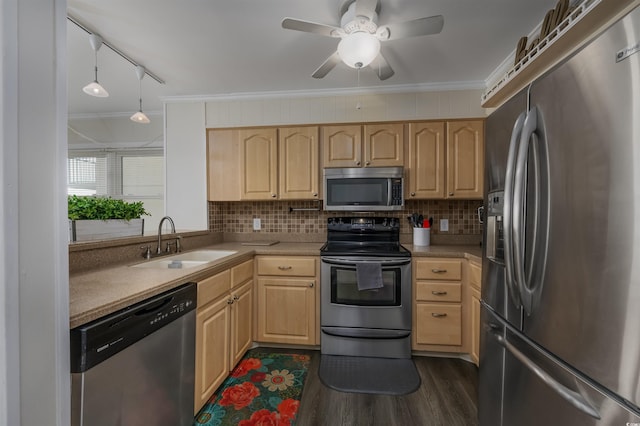 kitchen with stainless steel appliances, sink, light brown cabinetry, and decorative light fixtures