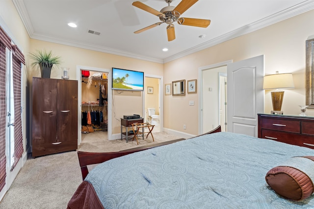 carpeted bedroom with crown molding, a walk in closet, ceiling fan, and a closet