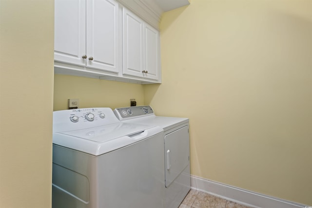 laundry area with light tile patterned floors, cabinets, and washing machine and clothes dryer