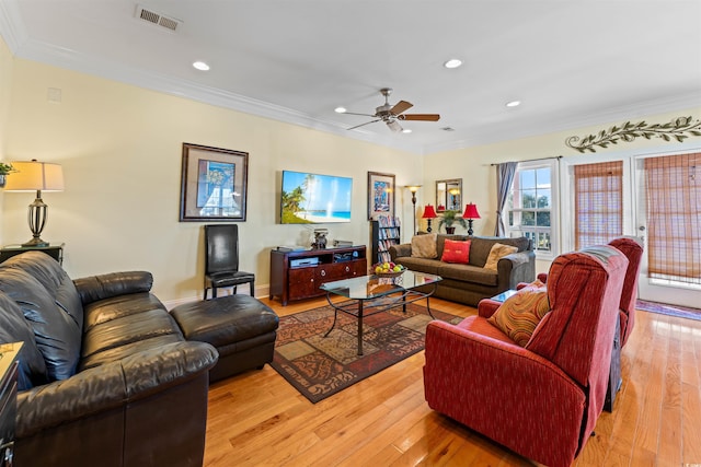 living room with crown molding, ceiling fan, and light wood-type flooring