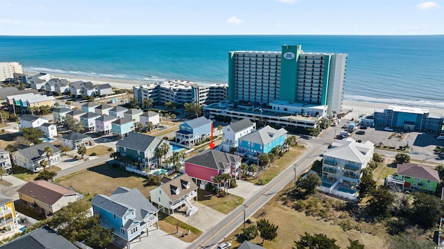 birds eye view of property with a water view and a beach view