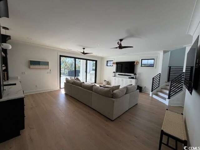 living room featuring ceiling fan and light hardwood / wood-style flooring