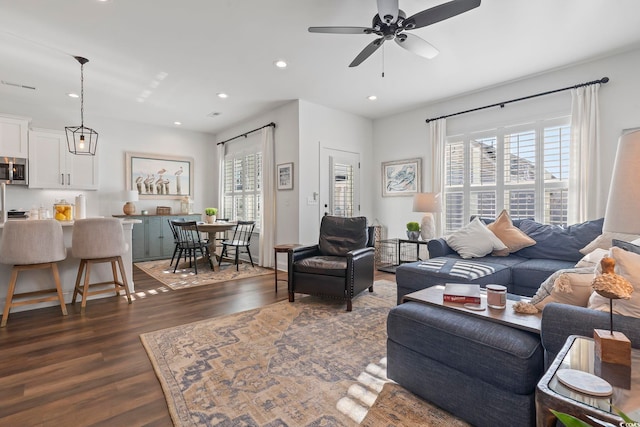 living room with plenty of natural light, dark hardwood / wood-style floors, and ceiling fan