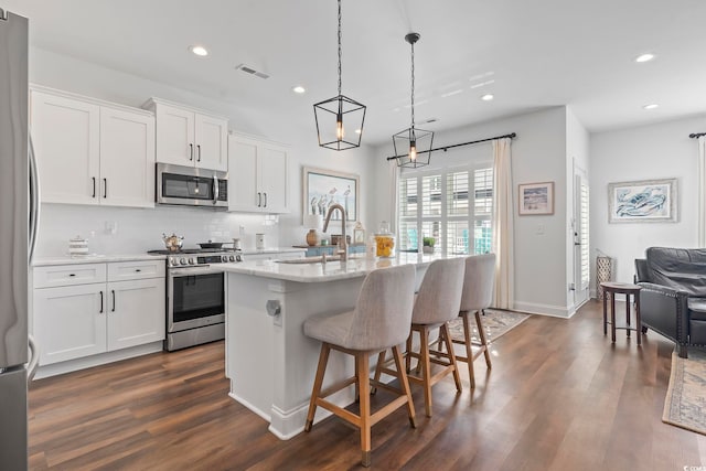 kitchen with white cabinetry, sink, an island with sink, and appliances with stainless steel finishes