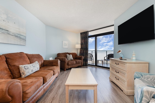 living room featuring hardwood / wood-style flooring, floor to ceiling windows, and a textured ceiling