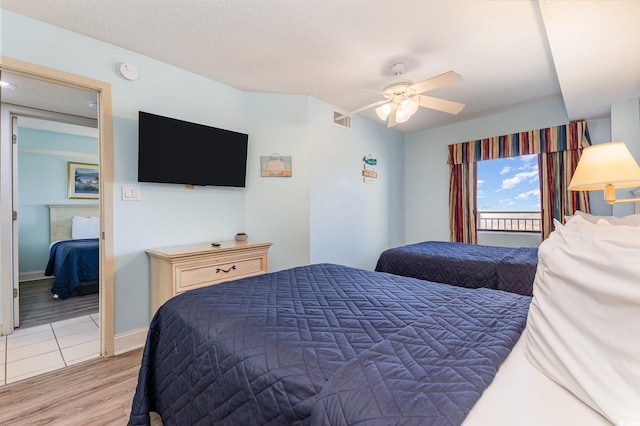 bedroom featuring ceiling fan, wood-type flooring, and a textured ceiling