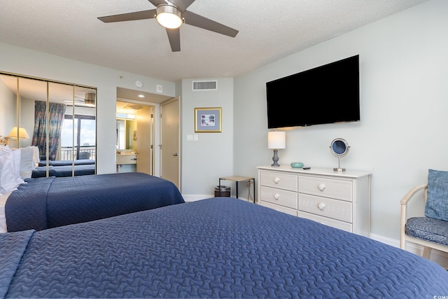 bedroom with ceiling fan and a textured ceiling