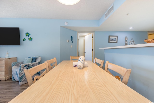 dining area featuring a textured ceiling and dark hardwood / wood-style flooring