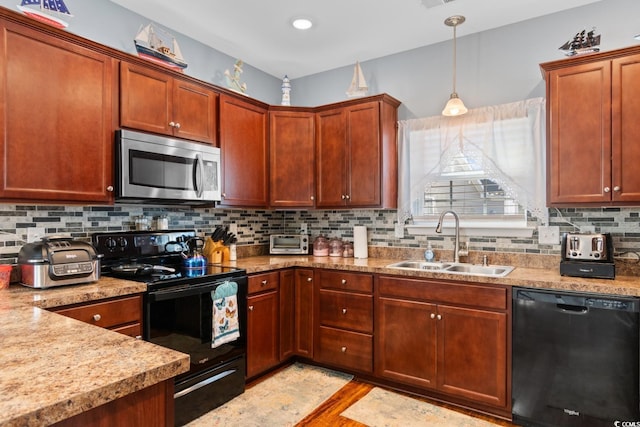 kitchen featuring decorative light fixtures, backsplash, light wood-style floors, a sink, and black appliances